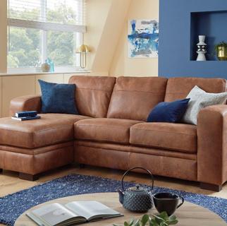 Brown leather corner sofa bed with blue scatter cushions and a cosy blue rug