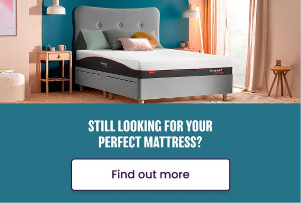 an uncovered mattress on a grey bed frame