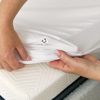 Person pulling on a mattress protector