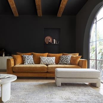 mustard yellow sofa and a white footstool