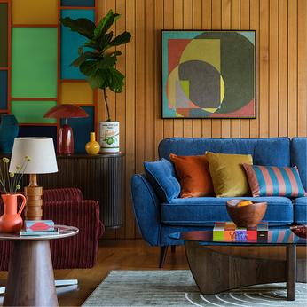 bright blue sofa in a retro styled room with wood panelled walls