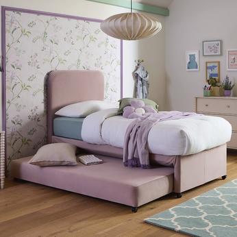 A pink childs bed with a trundle bed underneath