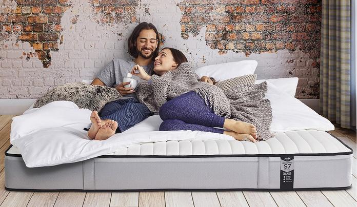 couple laying on a mattress on the ground