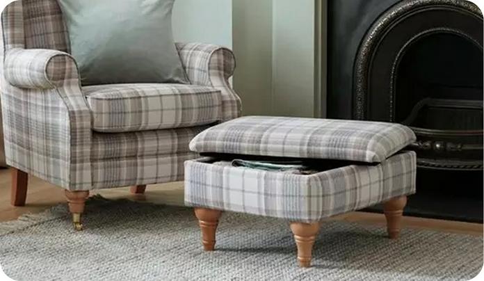 tartan patterned accent chair with matching footstool in front of an iron fireplace
