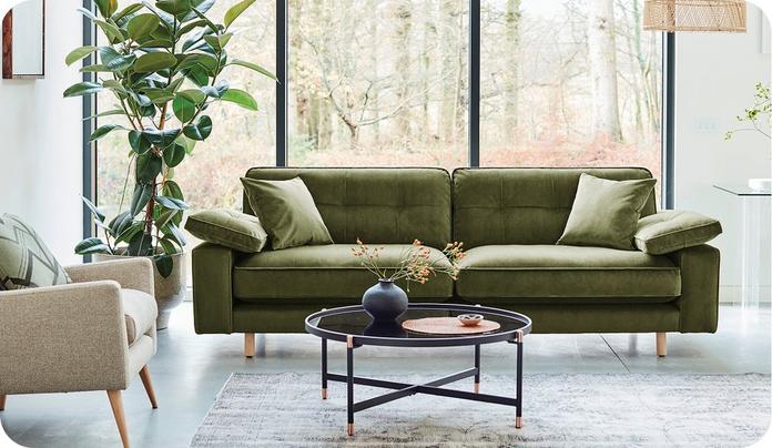 large green velvet sofa with glass topped coffee table