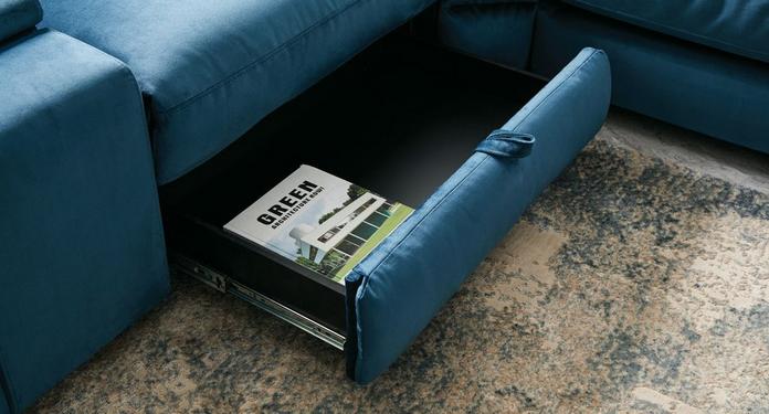 Close up of a sofa with a storage drawer with magazine inside