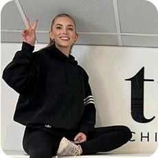 image a person sat on a counter giving a peace sign
