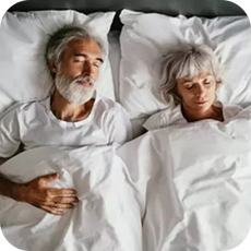 older couple laying on their backs in bed
