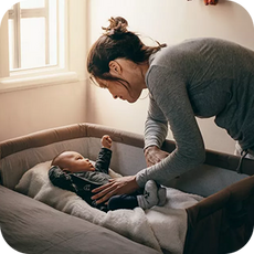 A person putting a baby down to sleep