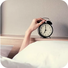 a person turning off an alarm clock