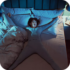 A person laying in bed in a star position
