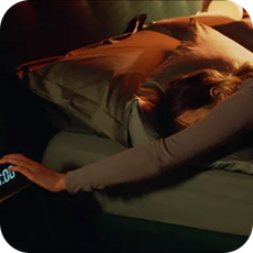A person reaching for the alarm clock