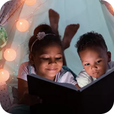 2 children reading a book together