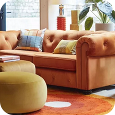 orange chesterfield sofa with yellow footstool