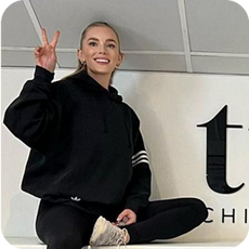 image a person sat on a counter giving a peace sign
