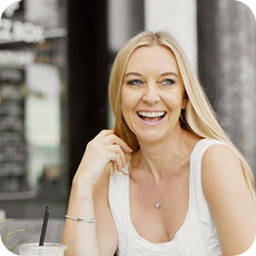 image a person with ling blonde hair and white vest smiling