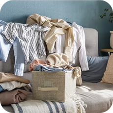 sofa covered in discarded clothes