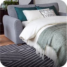 a grey sofa bed made into a bed