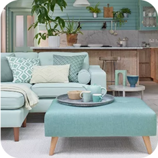 A light green corner sofa in a pastel coloured room