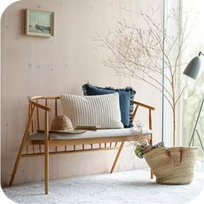 a wooden spindle back bench with scatter cushions