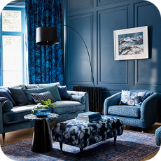 a blue sofa and accent chair in a blue room