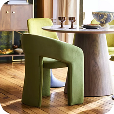a retro-styled green dining chair against a round dining table