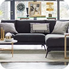 a large black corner sofa in a sundrenched room