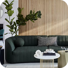 a curved green sofa with ball-shaped scatter cushions