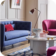 a deep blue trendy sofa next to a bright pink accent chair