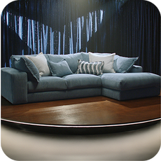 a large chaise corner sofa in blue on a stage