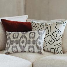 Cream sofa with patterned two scatter cushions and a red scatter