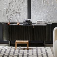Black sideboard with white paintings in the background and a black and white rug