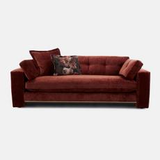 red sofa with gold trim and floral scatter cushion