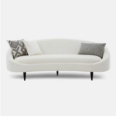 white curved sofa with black and white pattern scatters