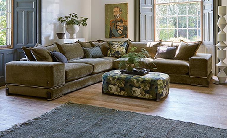 olive green corner sofa with floral accessories