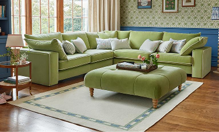 green corner sofa with blue backdrop