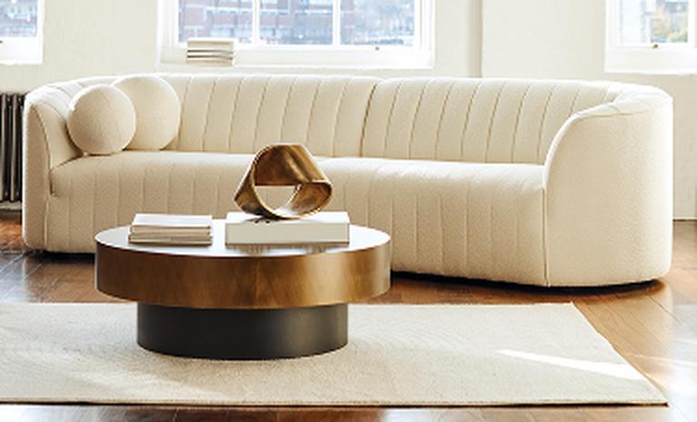 curved cream sofa with neutral backdrop