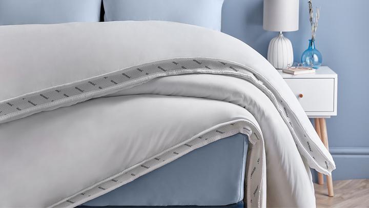 a white duvet on a blue bed frame