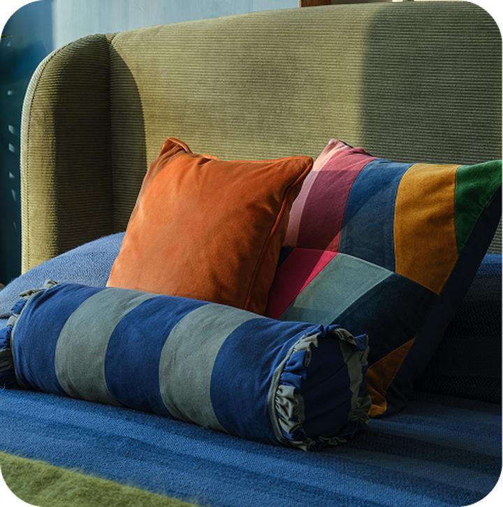 multi coloured scatter cushions on a bed