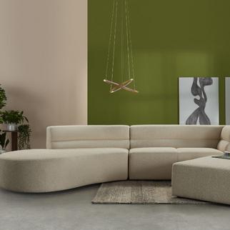 beige curved sofa against a light green wall