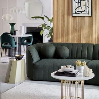 dark green boucle curved sofa wit two round cushions