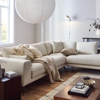 beige boucle corner sofa on a dark wood floor in a light living area