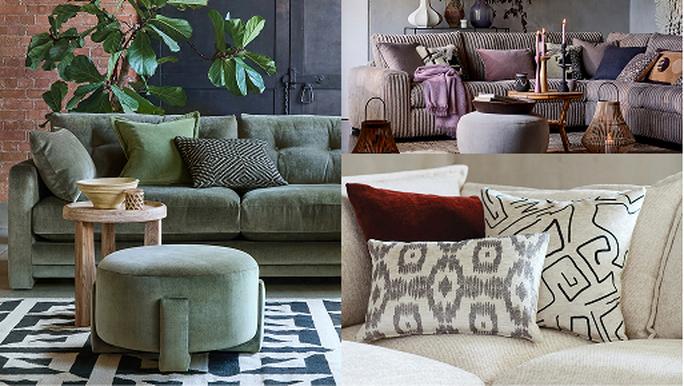 A green sofa with matching footstool in front of a tall plant