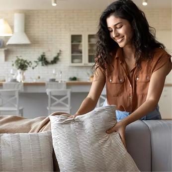 a person adjusting sofa cushions