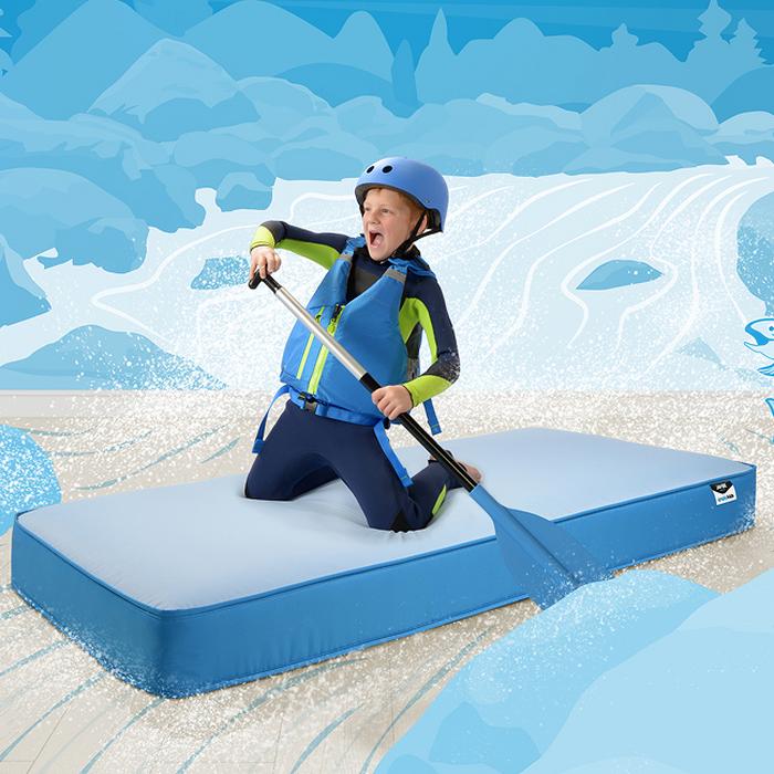 child riding a mattress like a kayak 