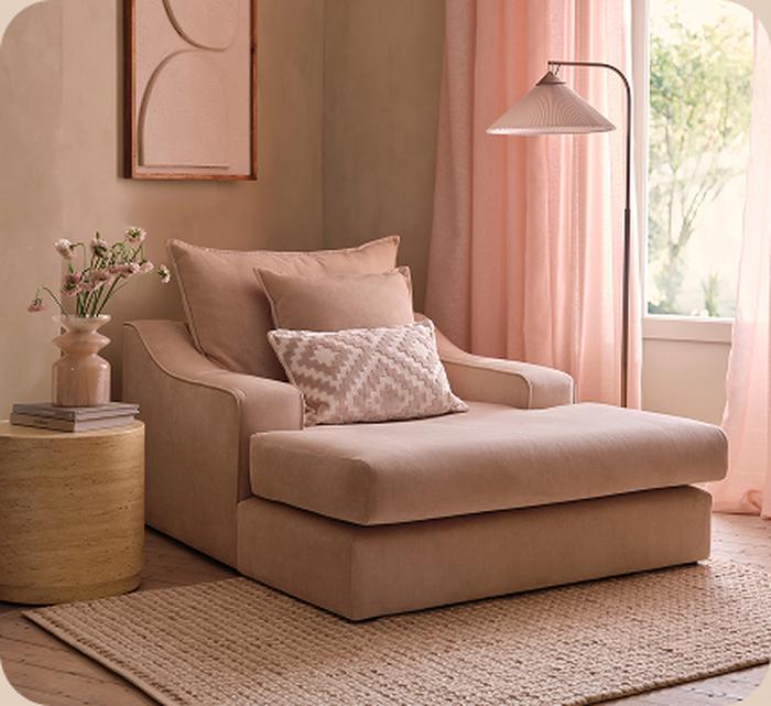 Pink cuddler sofa with pink background