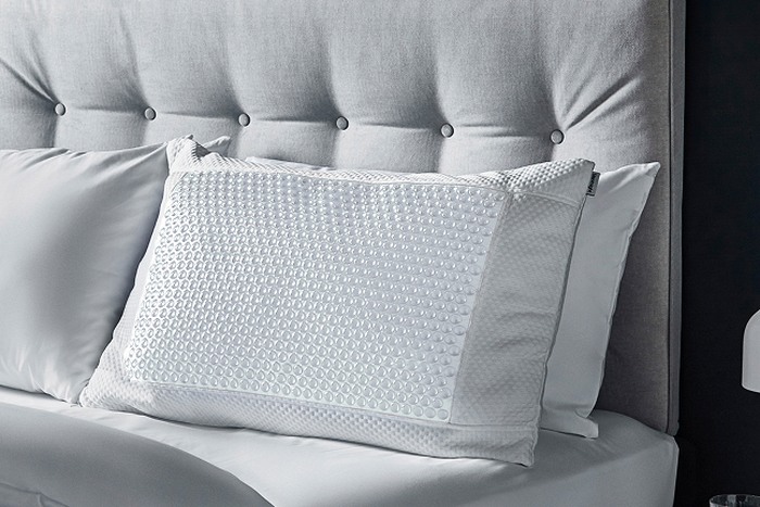 a pillow on a grey bed frame