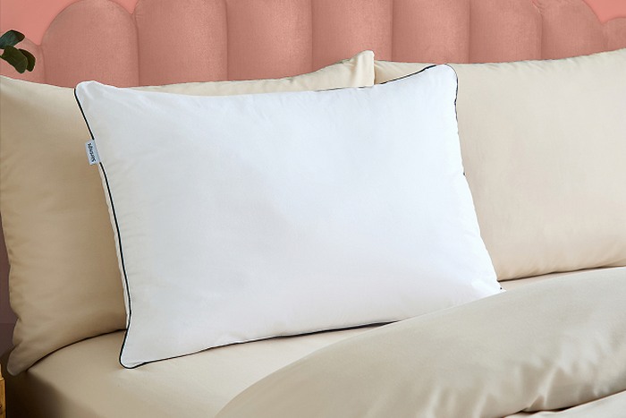 a pillow on a coral bed frame
