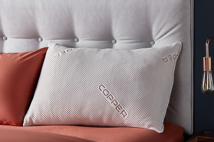 a pillow on a grey bed frame