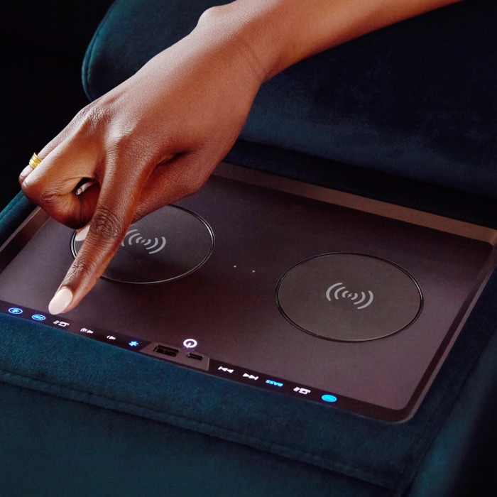 A hand reaching a control panel  